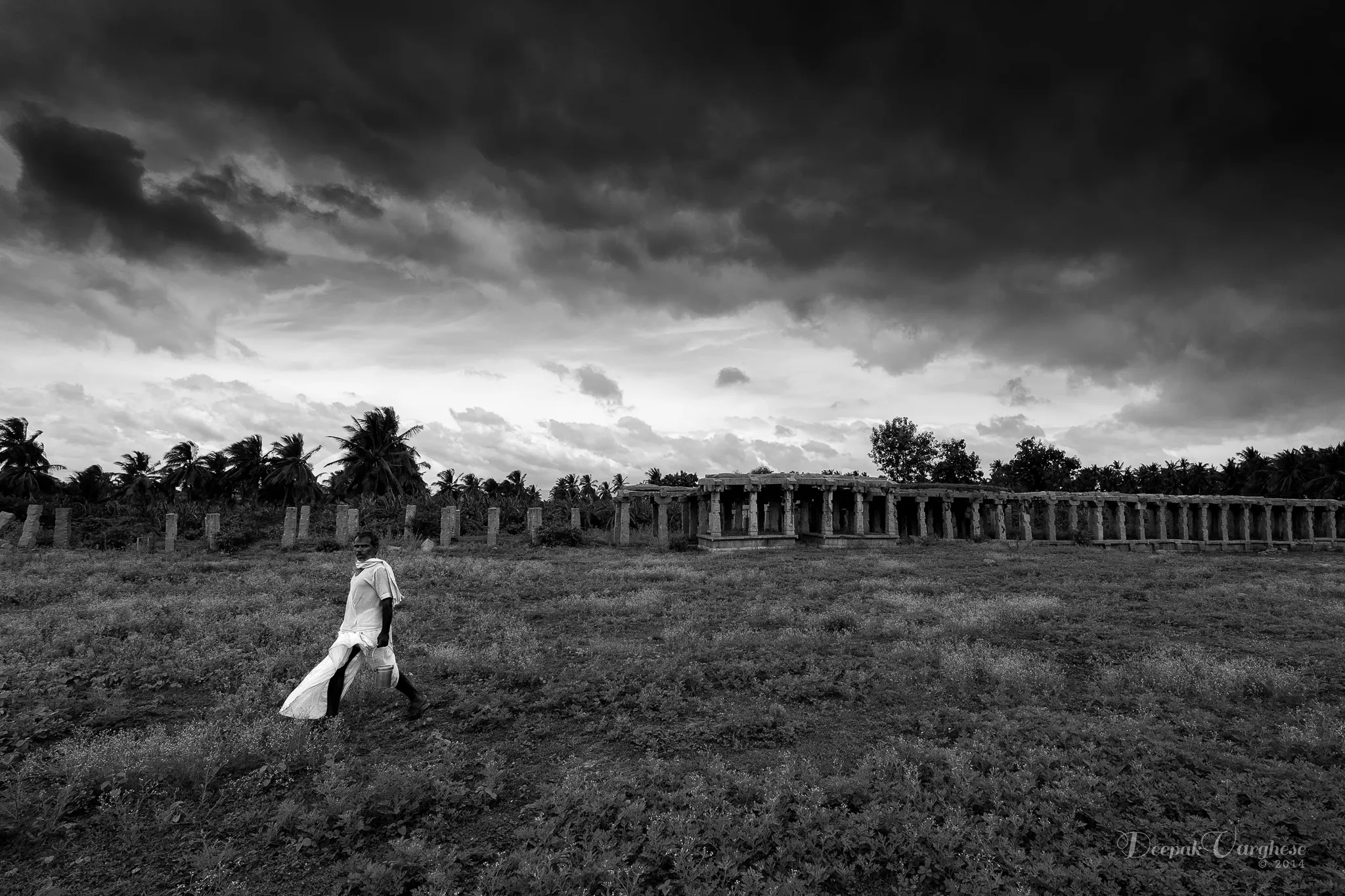 Man walking past Hampi ruins B&W
