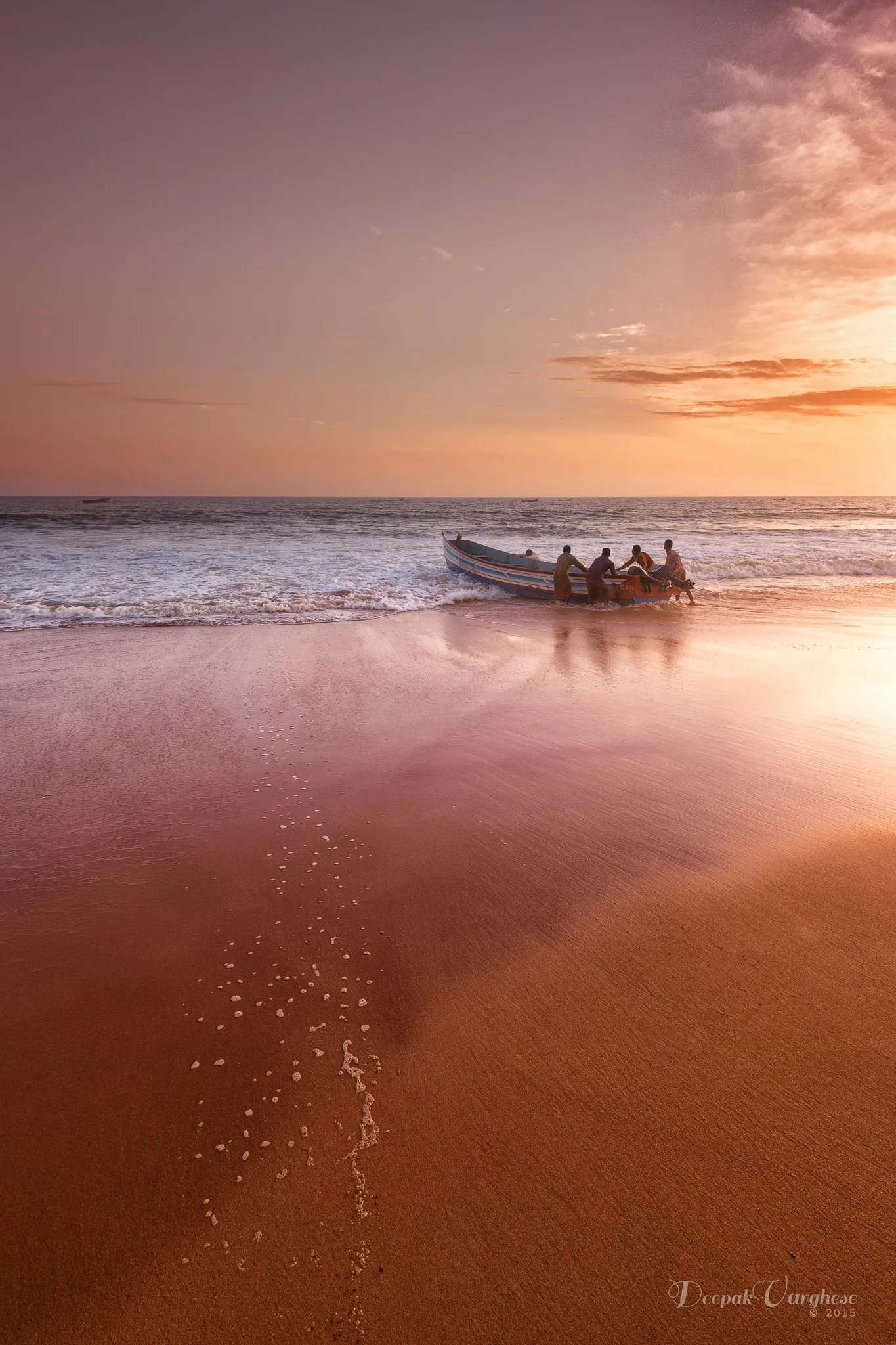 Fishing boat returning to shore at sunset, Shankumugham Beach, Kerala