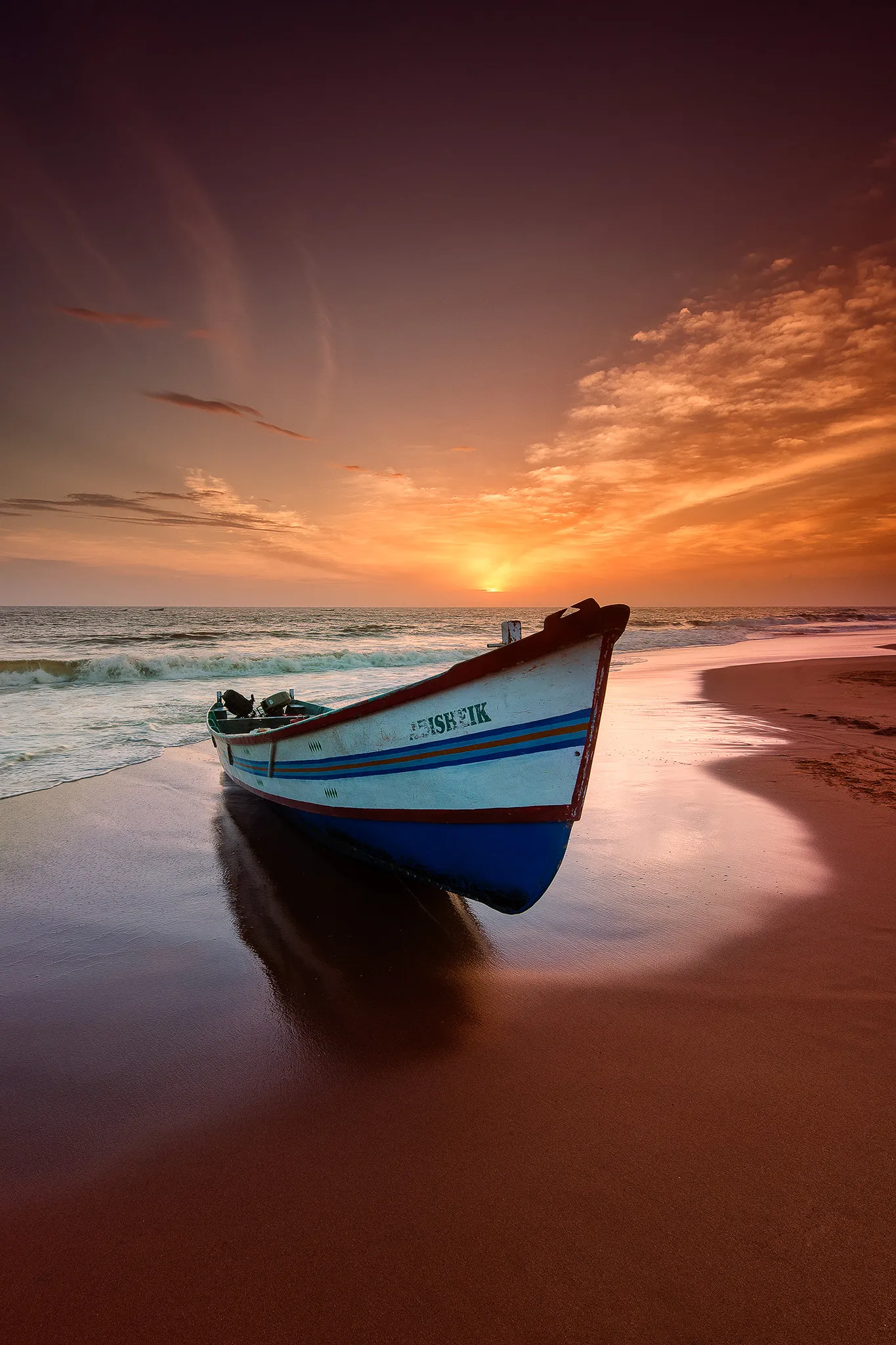 Fishing boat on Shankumugham Beach with golden sunset sky, Kerala