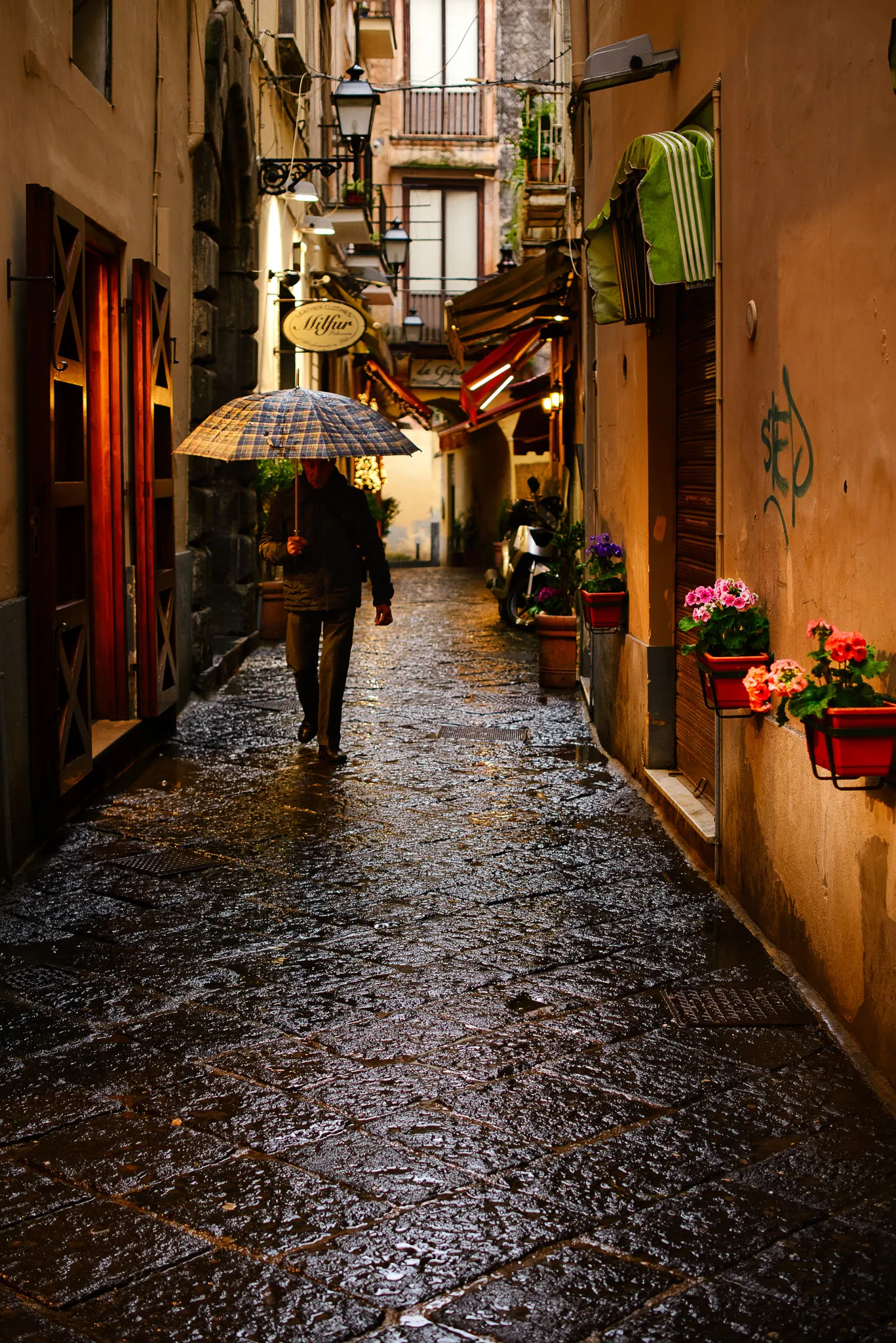 Wet cobblestones in Venice at night reflecting warm lamplight and coloured lights